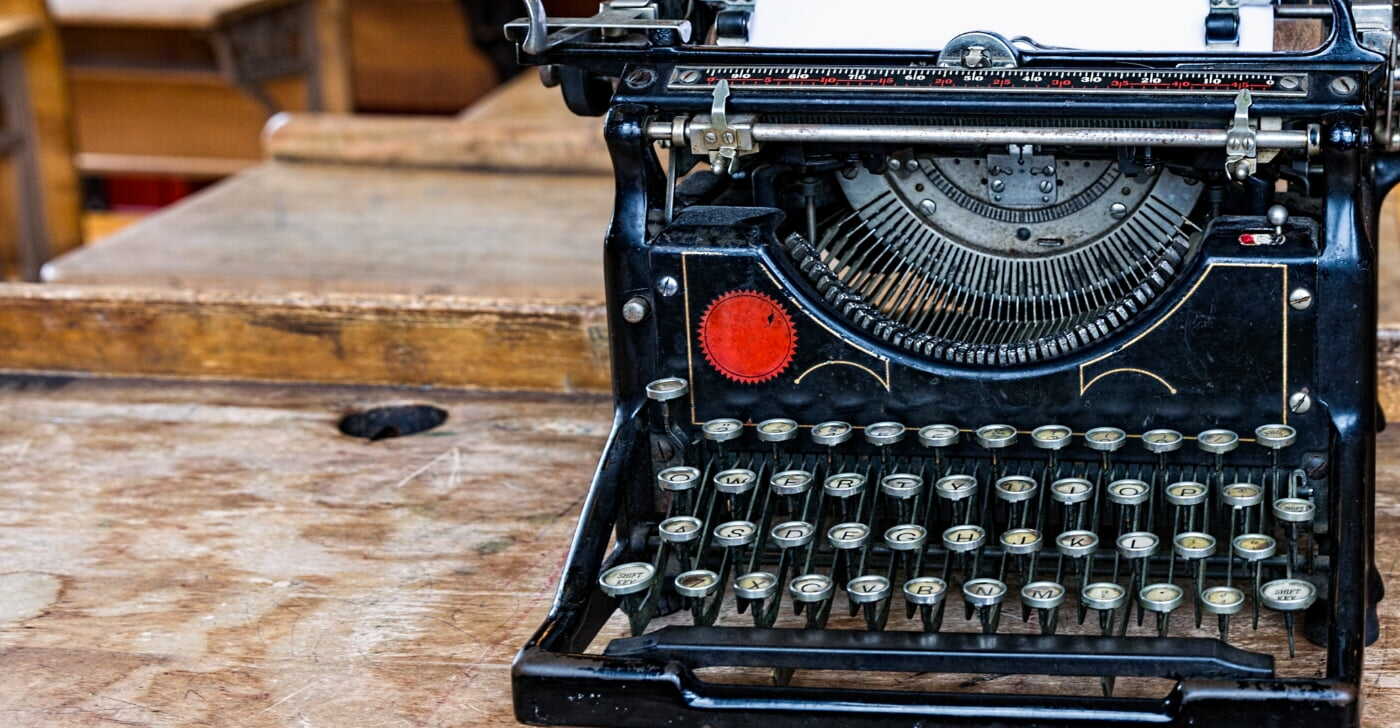 Black antique typewriter with red starburst logo