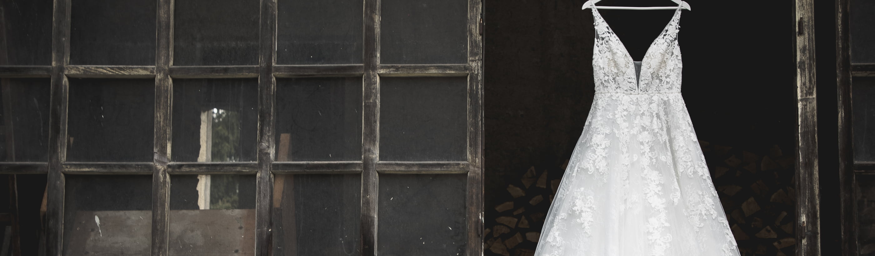 A wedding gown hung on a black industrial garage door